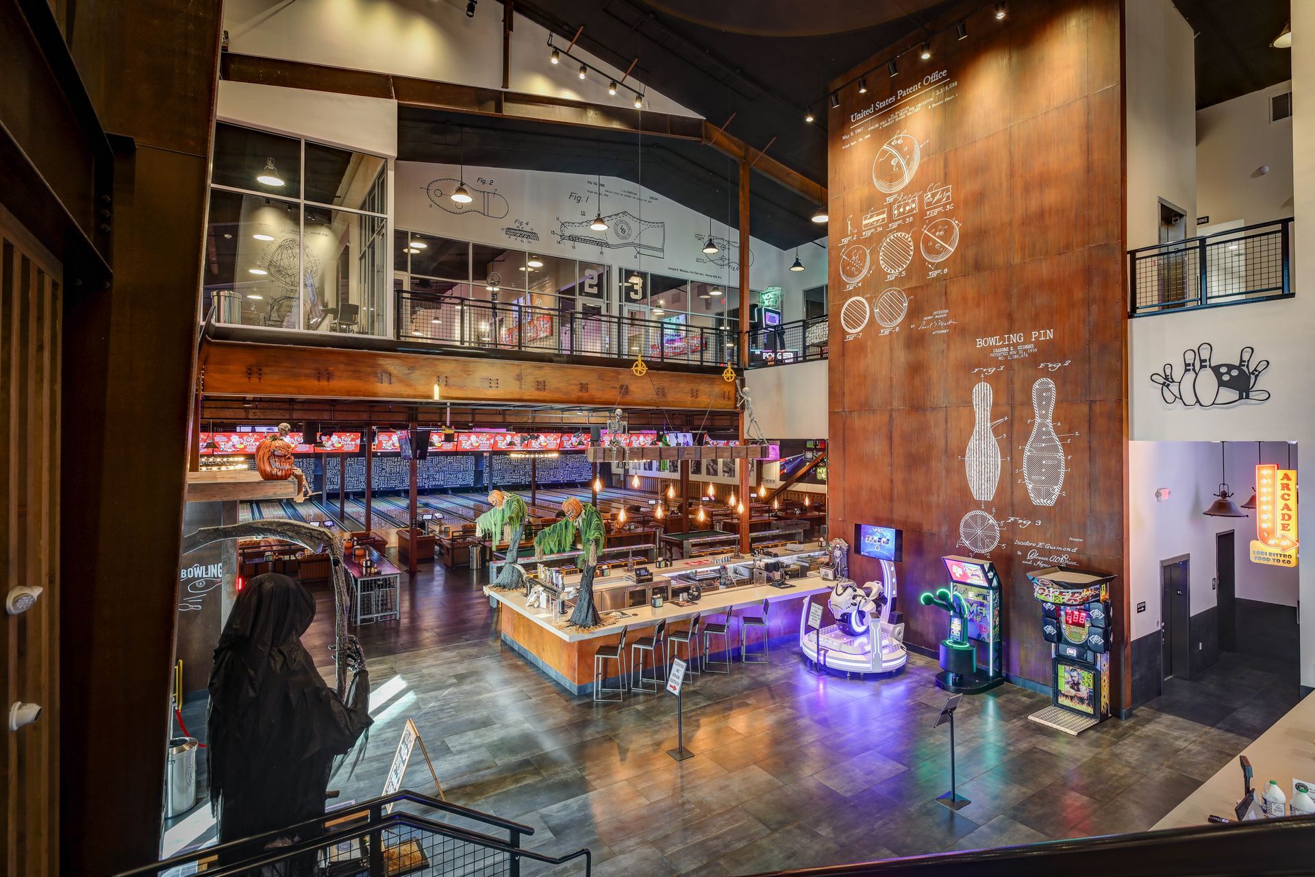 Spacious modern bar and lounge interior with warm lighting, a mezzanine, and colorful neon accents