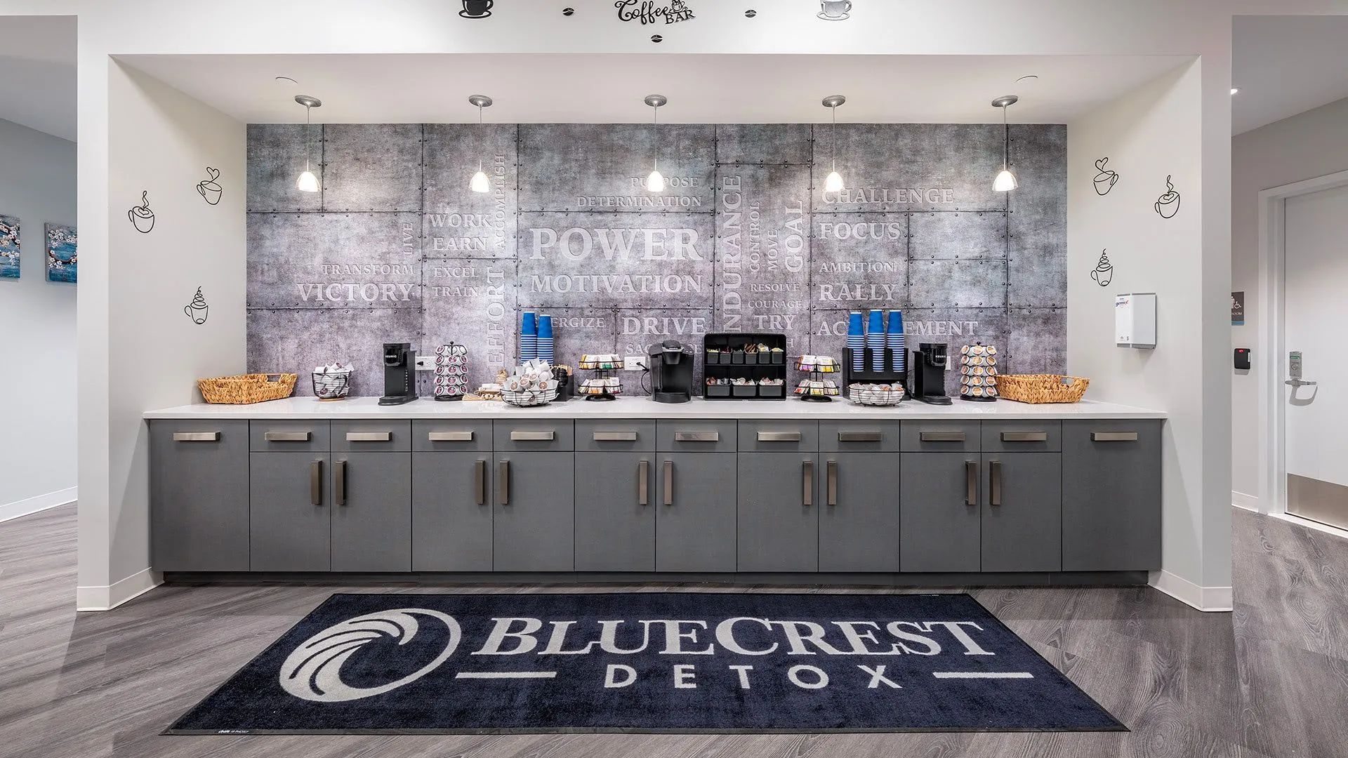 Bluecrest Legal reception counter with coffee station, gray cabinetry, and branded floor mat