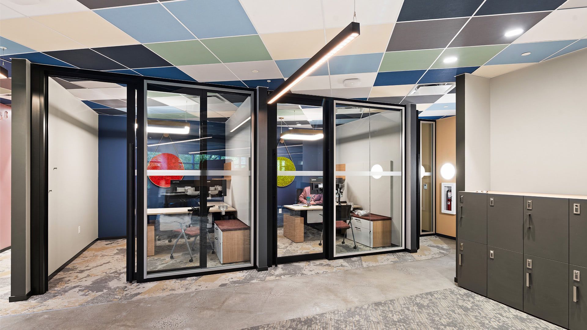 Ramboll Princeton — Princeton, NJ
Wide interior overview shot showing the glass-walled private workspaces with the multi-colored tile ceiling and grey carpet