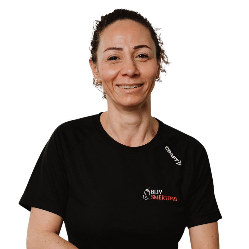Smilende person i en sort T-shirt med logo, stående mod en hvid baggrund.