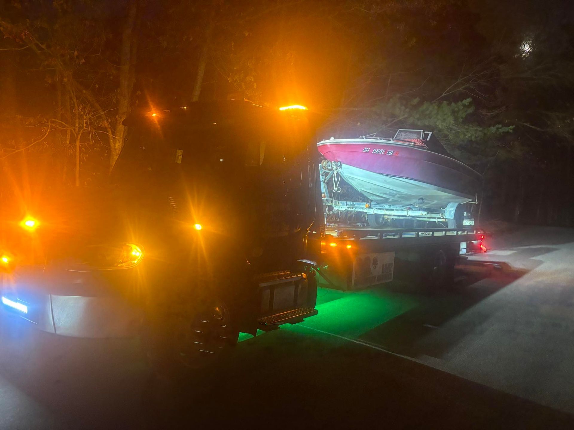Two vehicles at night with bright orange and green lights on a foggy road