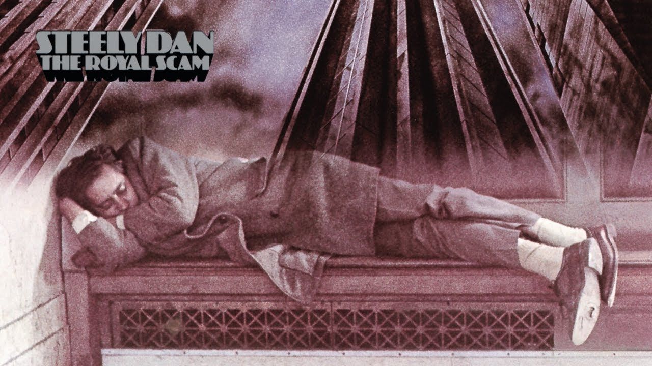Album cover showing a man reclining on a couch in a pink-toned room, with “Sheridan” text in the corner