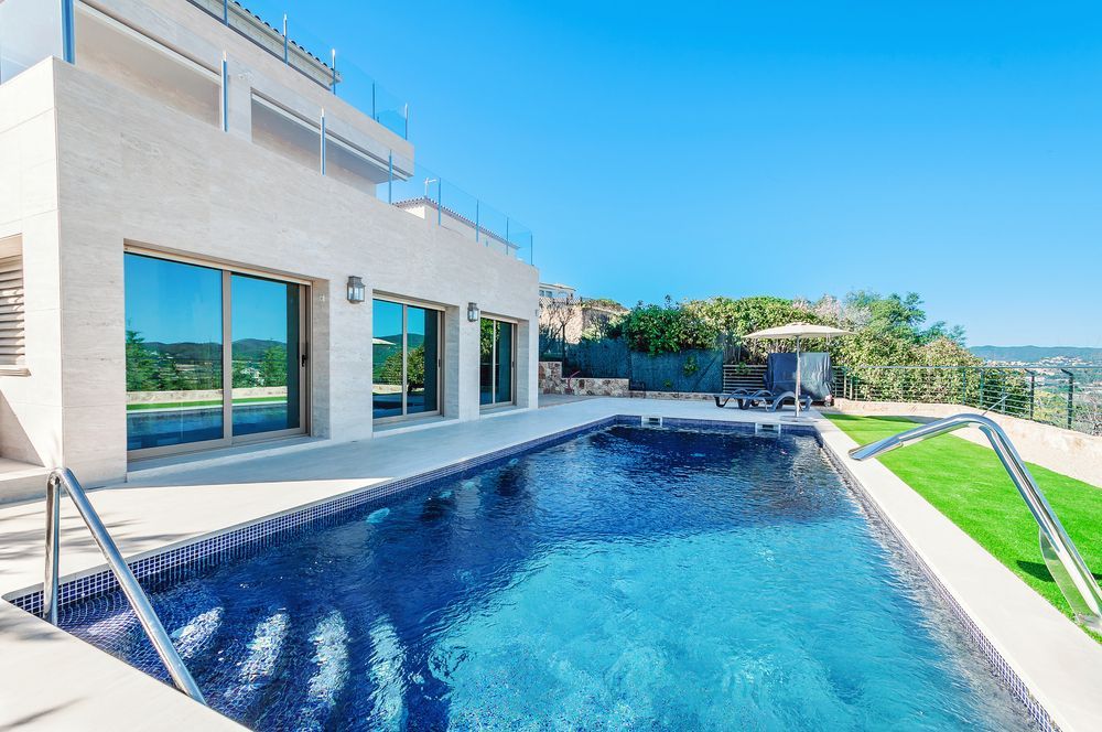 There Is A Large Swimming Pool In Front Of A Large House — Solitary Island Pools in Macksville, NSW