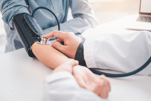 Doctor taking blood pressure from a patient with a cuff and stethoscope