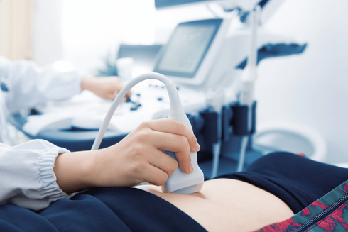 Ultrasound exam with clinician scanning a patient’s abdomen using a handheld probe