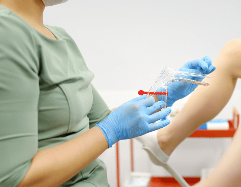 Gloved healthcare worker handling a syringe near a patient’s arm in a clinic setting