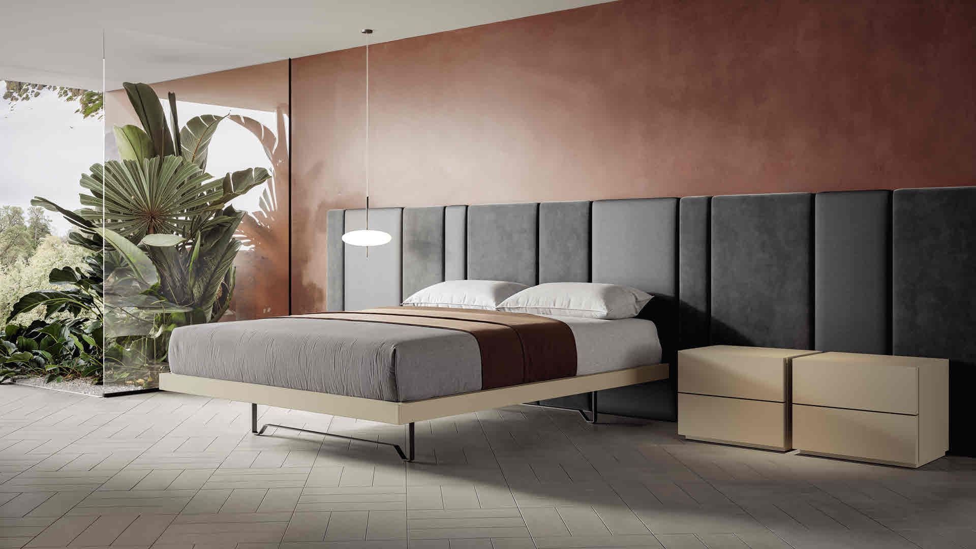 Camera da letto moderna con letto, testiera scura, biancheria da letto beige, comodini in legno e piante vicino a una grande finestra.