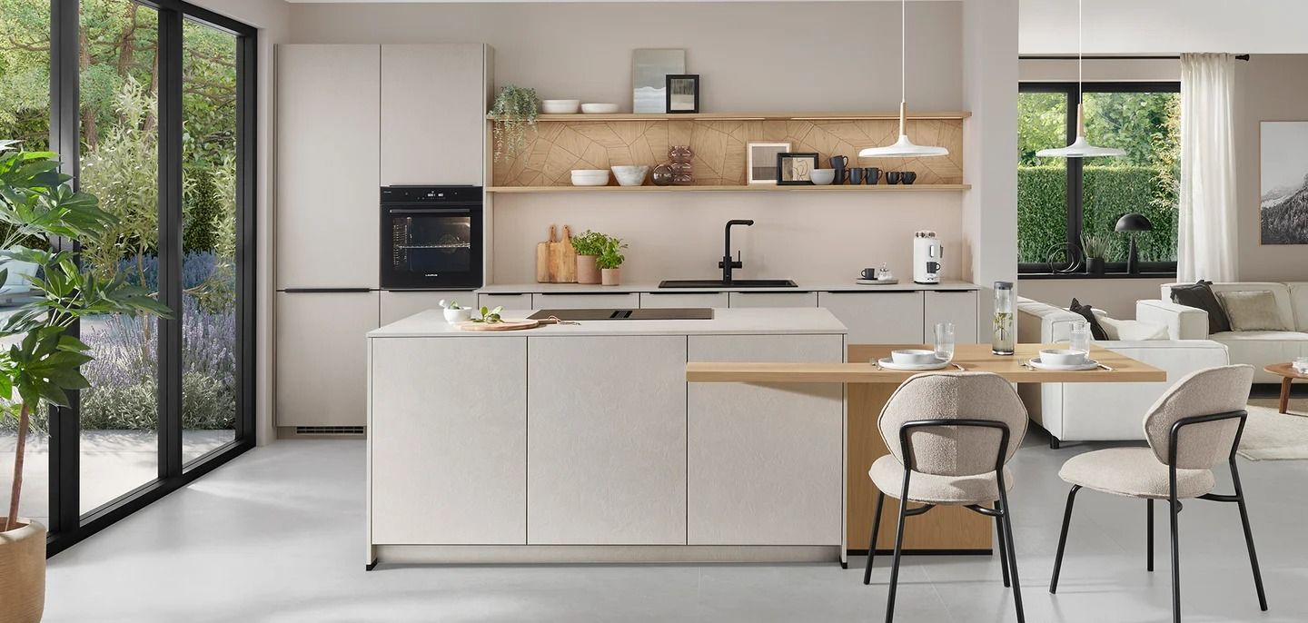 Cucina e zona pranzo luminose e moderne con mobili bianchi, mensole in legno e ampie finestre.