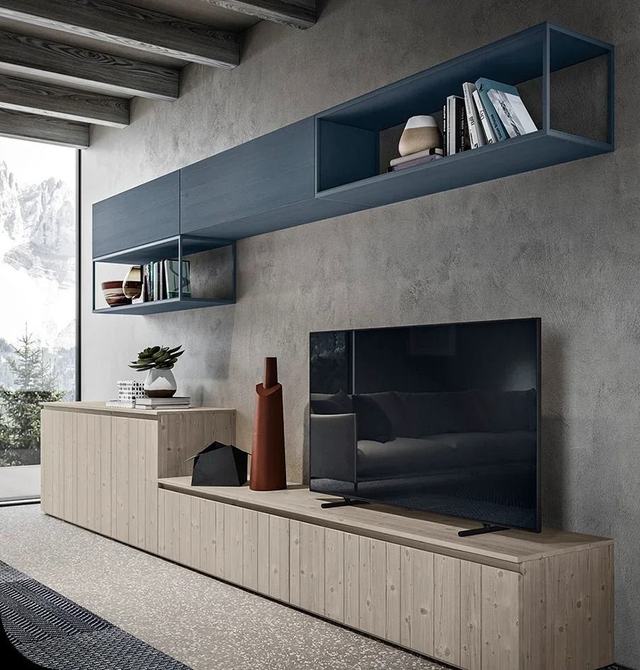 Soggiorno moderno con mensole blu a muro, mobile porta TV beige e televisore su una parete in cemento.