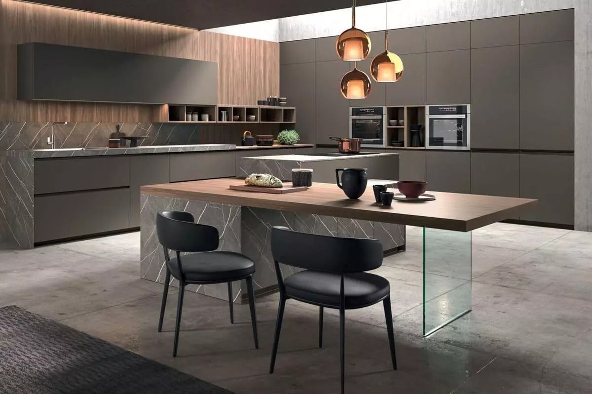 Cucina moderna e minimalista con isola, mobili scuri, lampade a sospensione e sedie da pranzo nere.