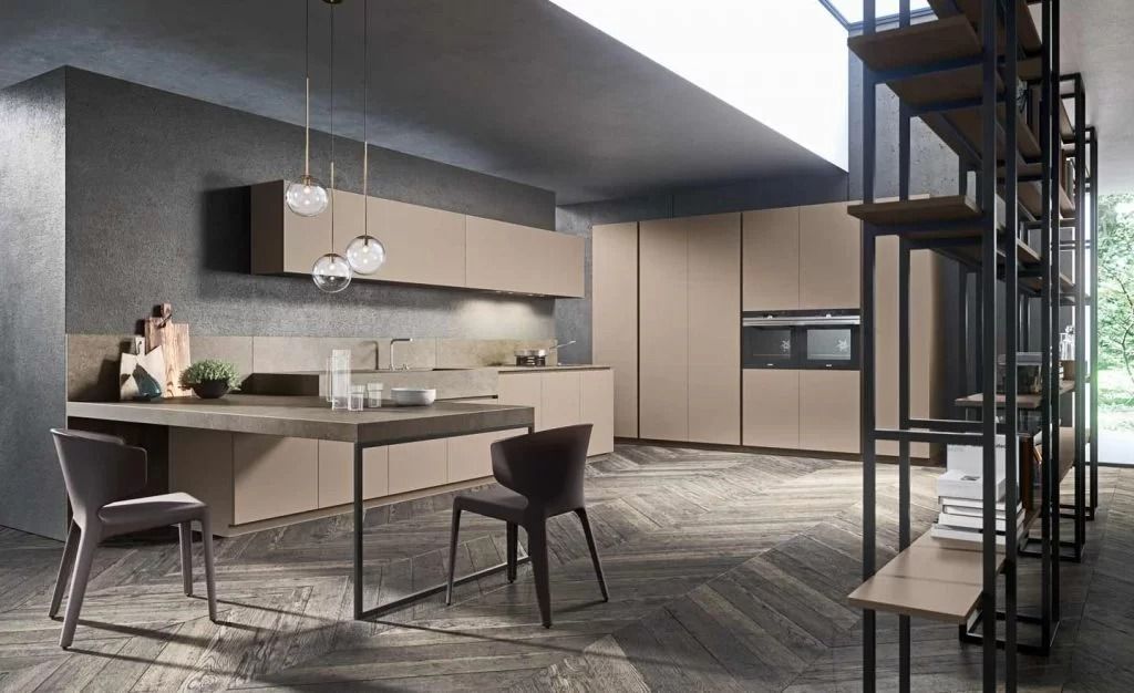 Cucina e zona pranzo moderne a pianta aperta con finiture grigie, lampade a sospensione e una scala accanto a grandi finestre.