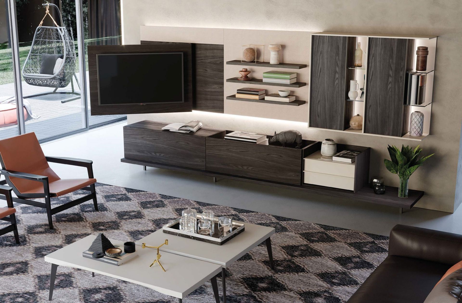 Soggiorno moderno con divano angolare grigio, TV a parete, tappeto a motivi geometrici e tavolino da caffè in vetro.