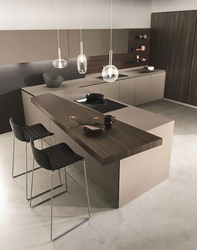 Cucina moderna con isola scura, sgabelli da bar, lampade a sospensione e mobili grigi minimalisti.