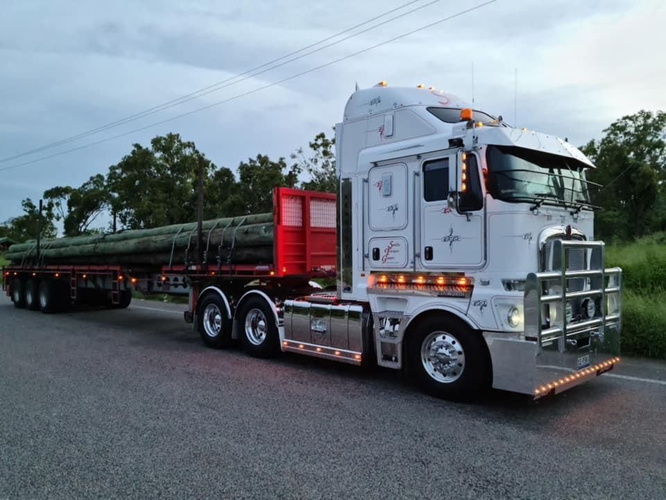 A White Semi Truck with A Red Trailer Is Parked on The Side of The Road — Smillie Transport Pty Ltd in Two Mile, QLD