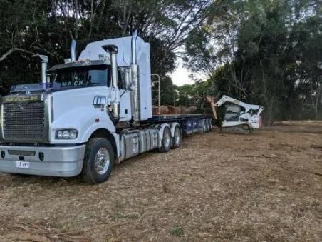 A White Semi Truck Is Parked in A Field with Trees in The Background — Smillie Transport Pty Ltd in Mackay, QLD