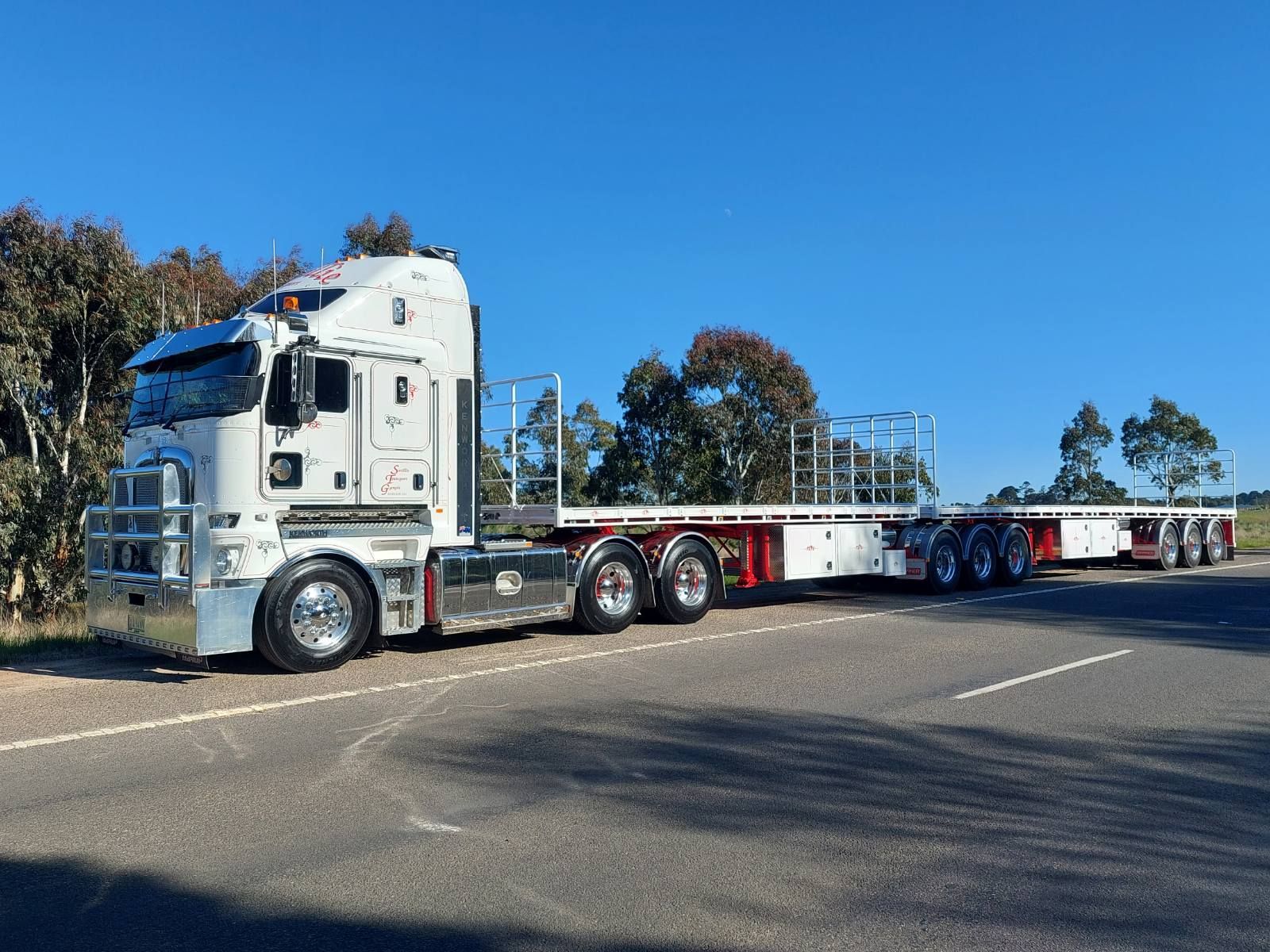 A Large Flat bed Truck Is Parked ion the side of the road — Smillie Transport Pty Ltd in Two Mile, QLD