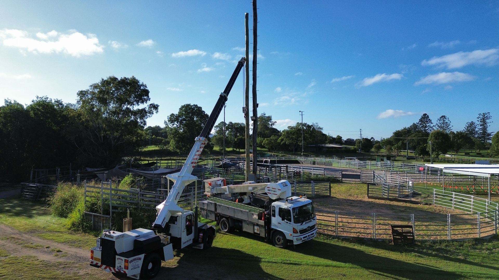 Crane Truck Lifting a Tall Pole at a Worksite on a Sunny Day — Smillie Transport Pty Ltd in Two Mile, QLD