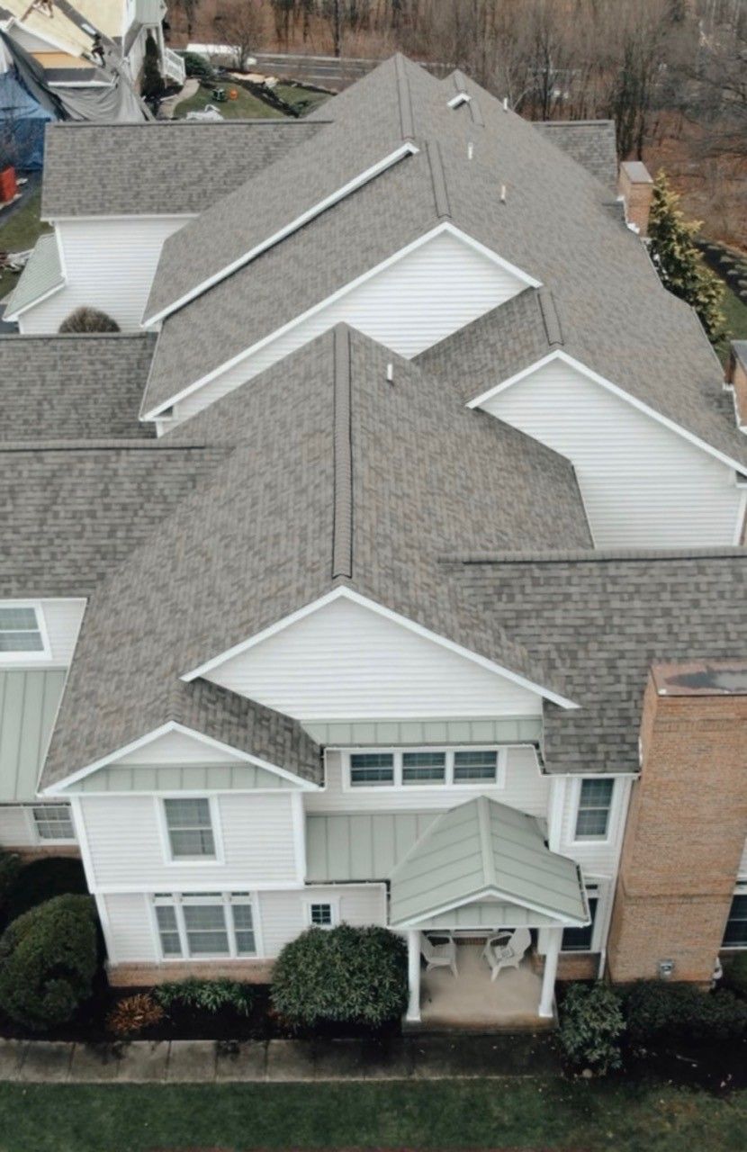 Skilled roofer setting asphalt shingles on a residential roof in Northeast Pennsylvania