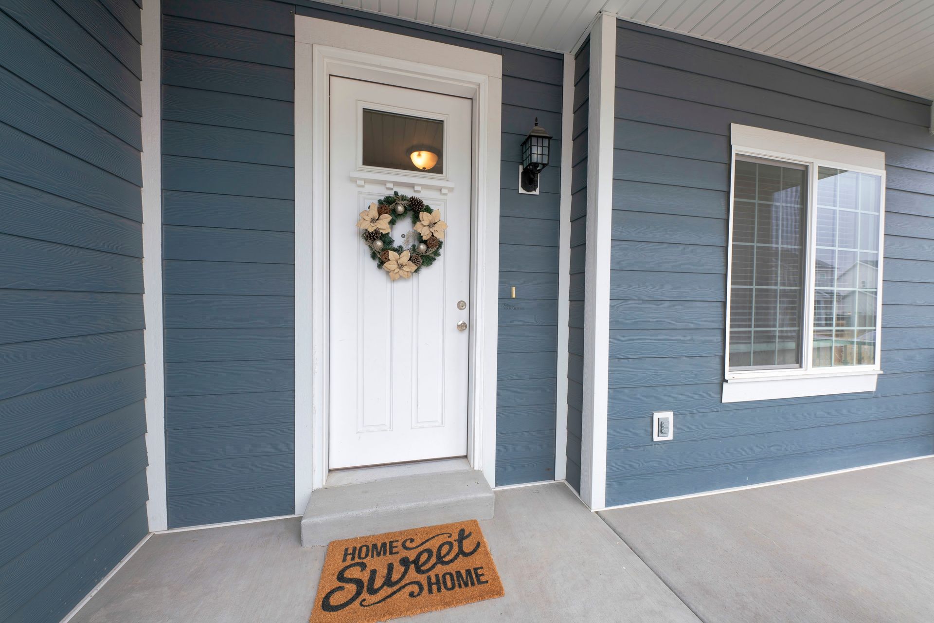Blue house exterior with white door, wreath, and 