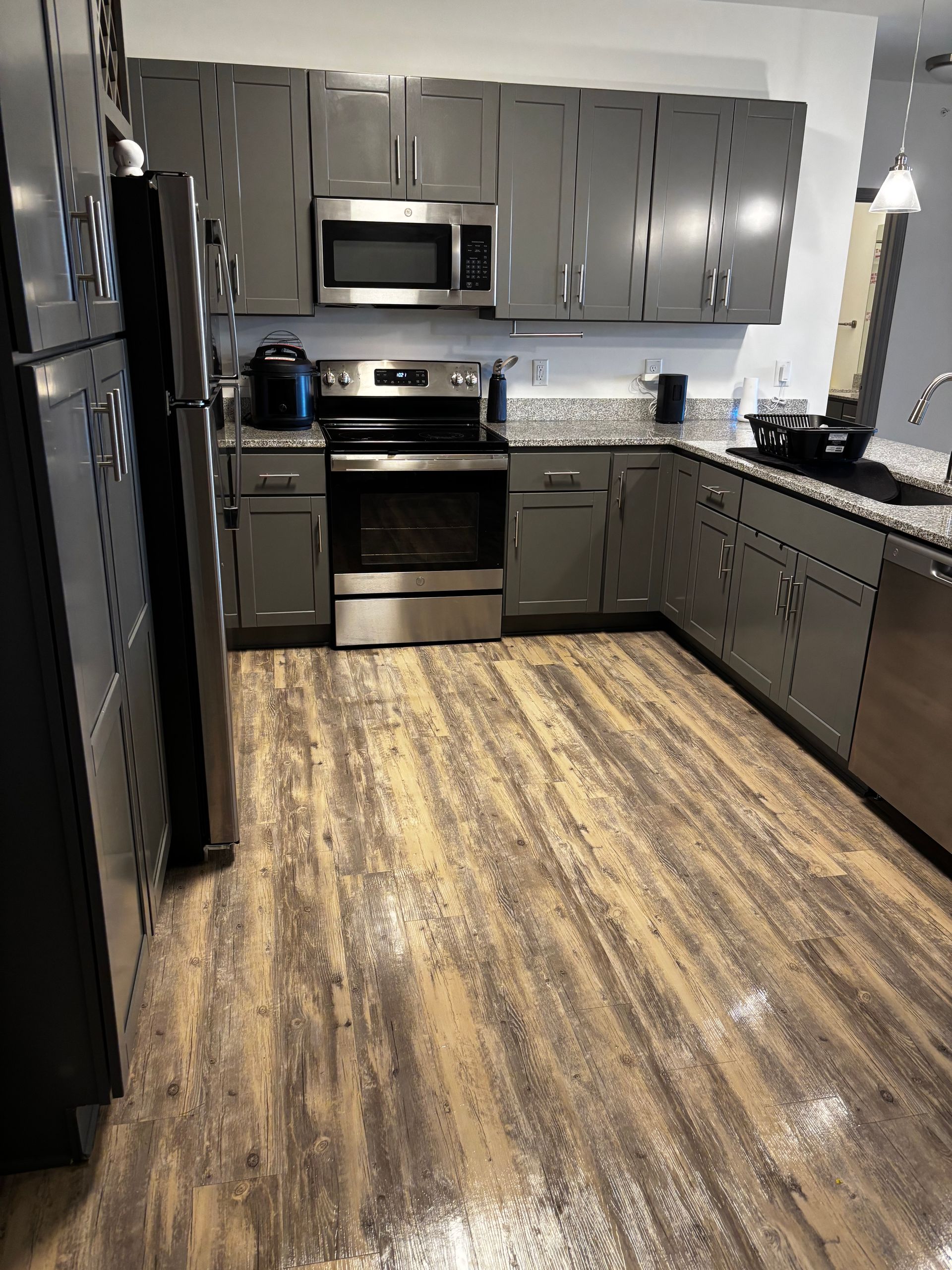 A kitchen with stainless steel appliances and gray cabinets