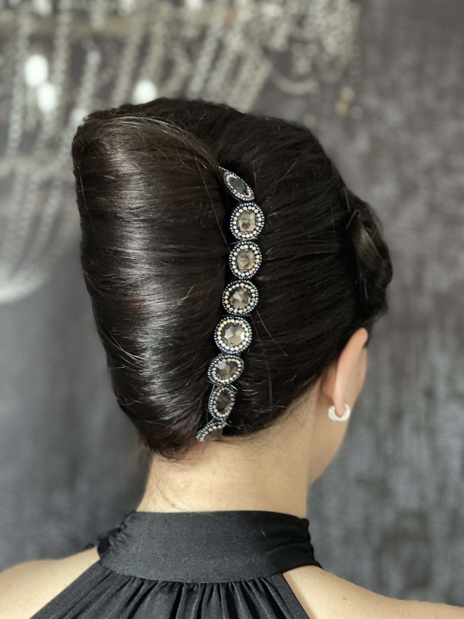 Eine Frau in einem schwarzen Kleid hat ihre Haare zu einem Dutt gebunden