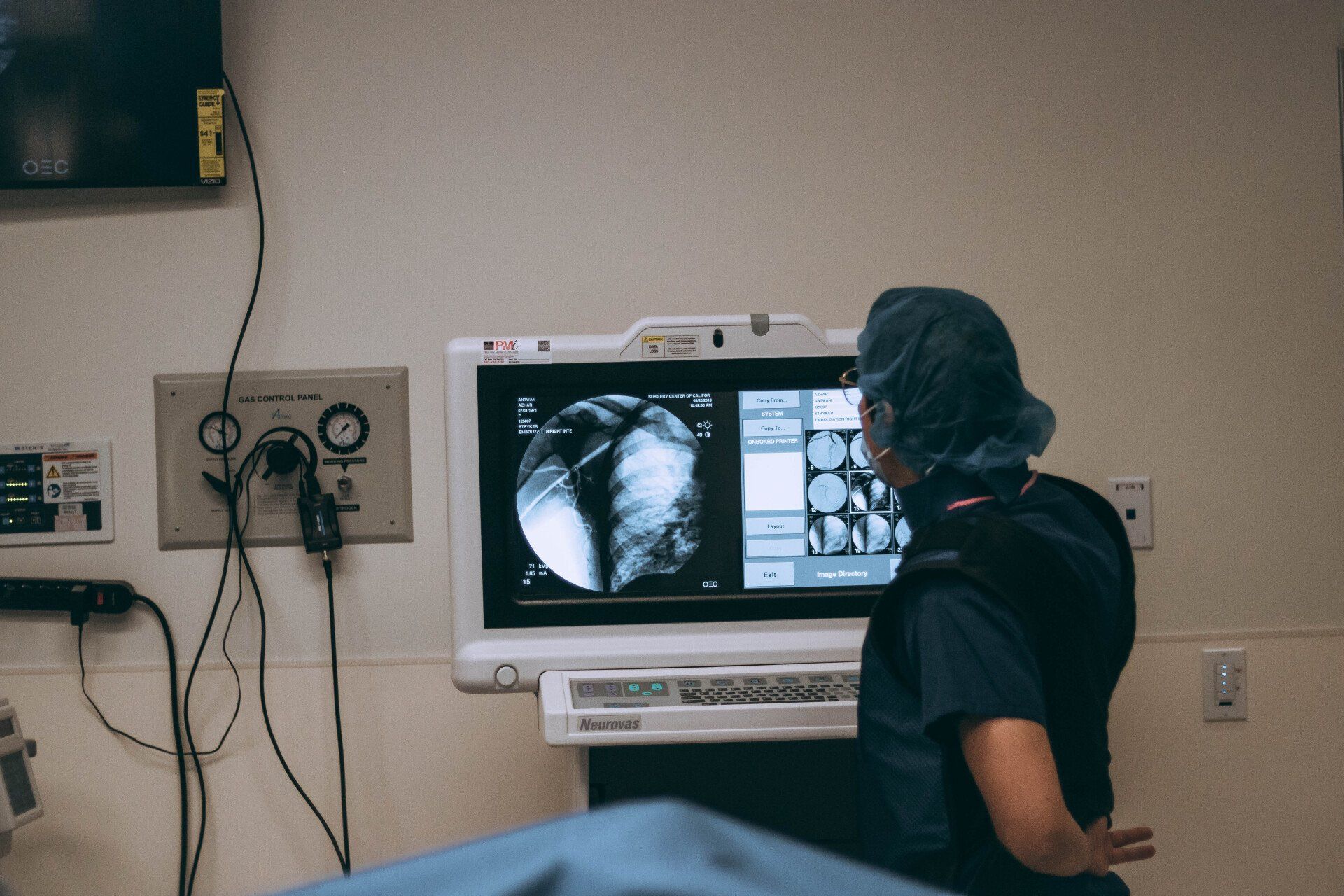 A surgeon is looking at an x-ray in an operating room.
