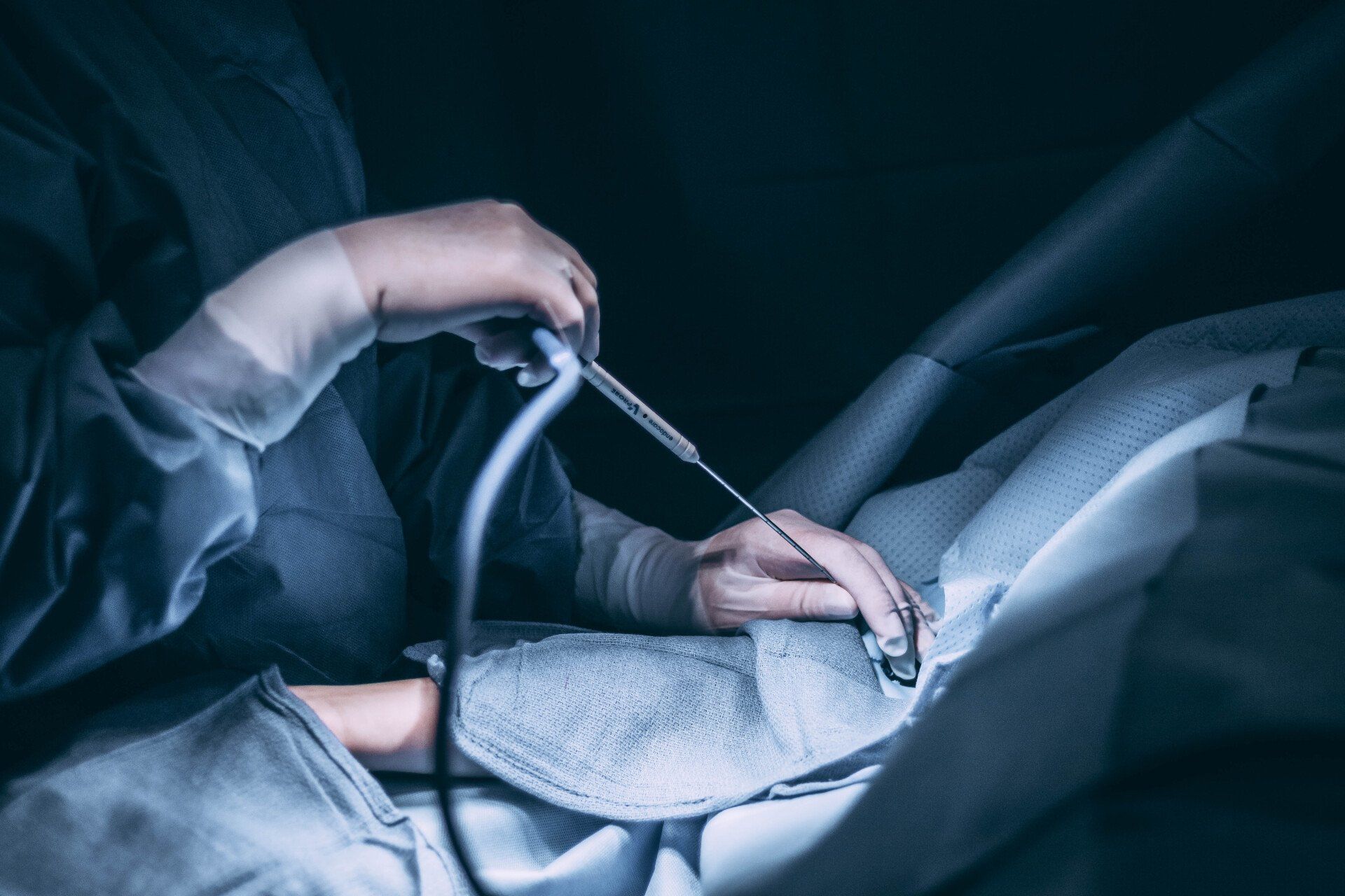 A surgeon is operating on a patient in an operating room.