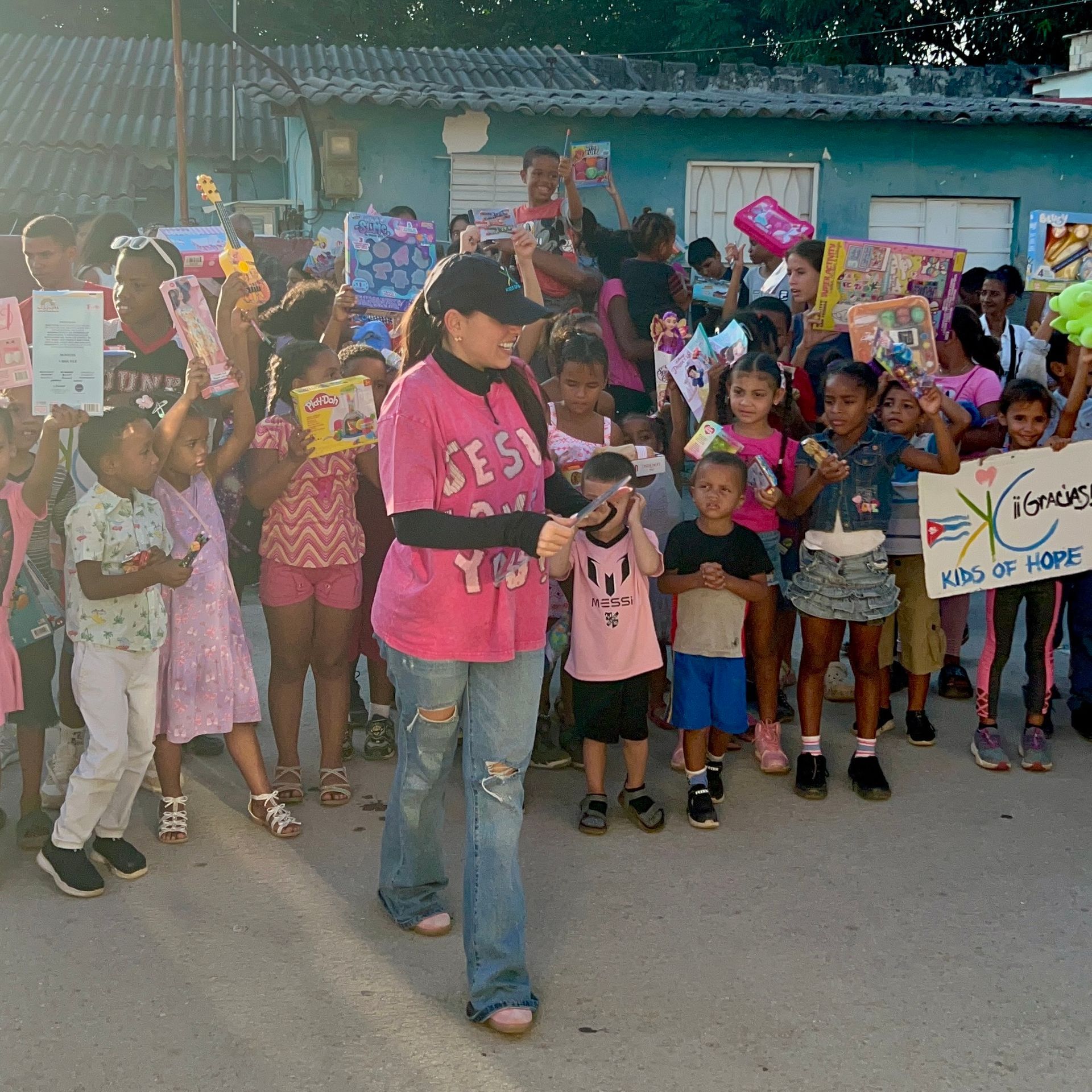 A group of children and an adult outdoors, holding toys and a
