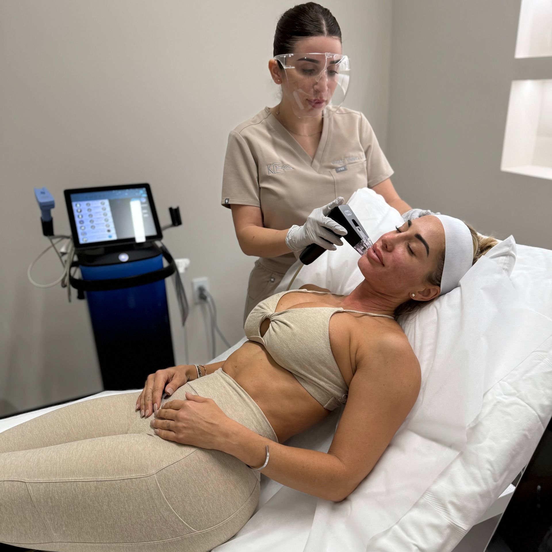 A clinical aesthetician using a handheld device to perform a cosmetic facial treatment.
