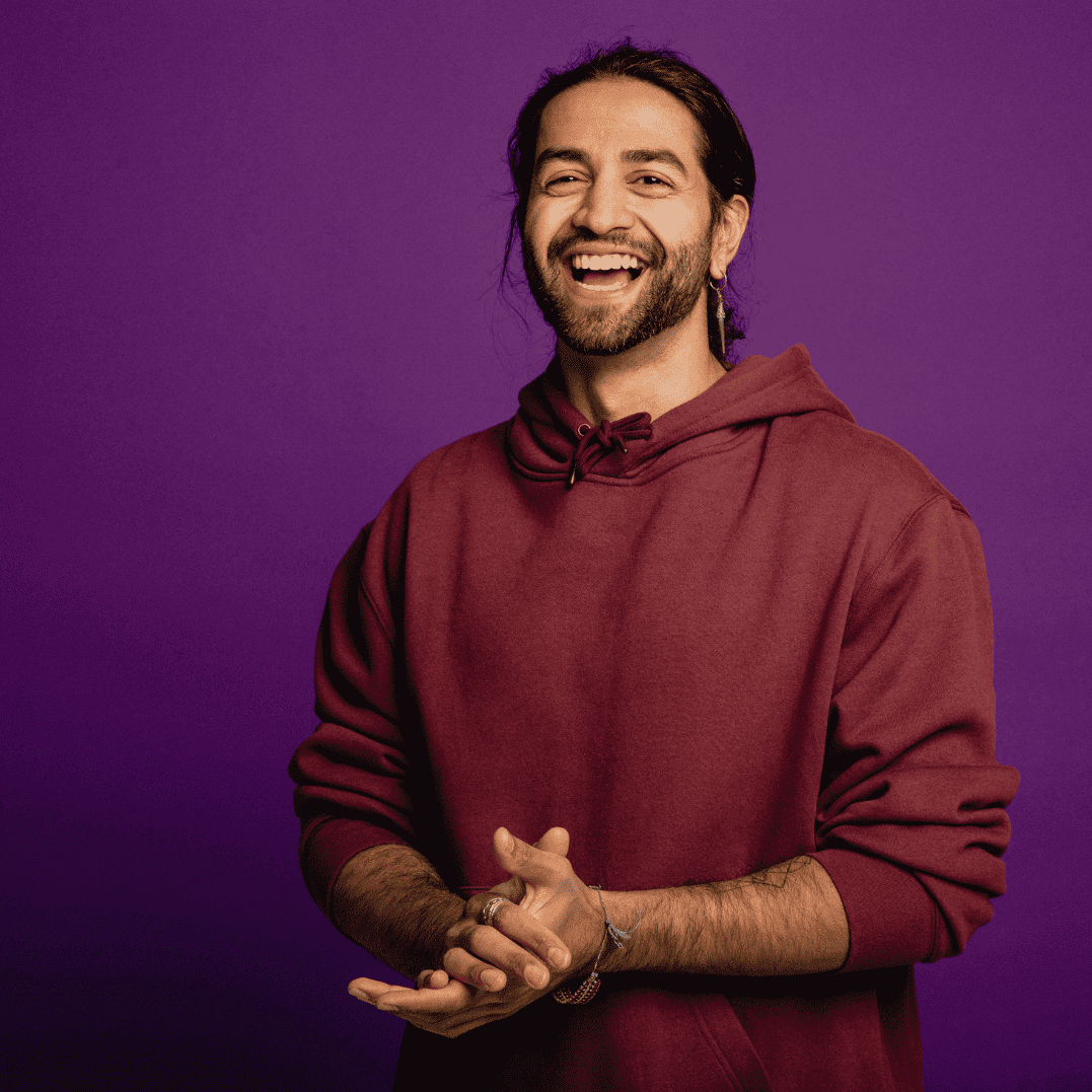 Data Engineering Recruitment specialists wearing a black hat and purple sweater, carrying a backpack against a purple background