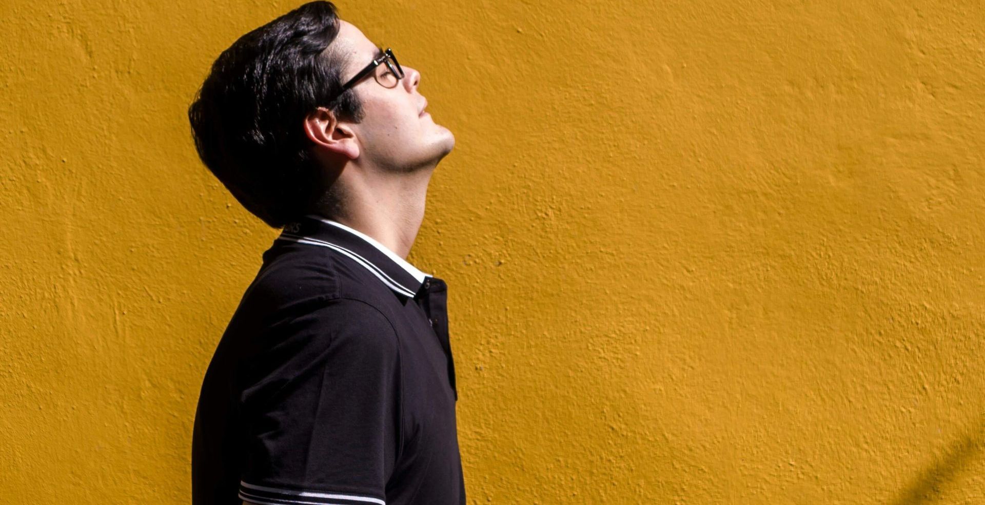 Man contemplating how to attract top data talent in 2025. Yellow background