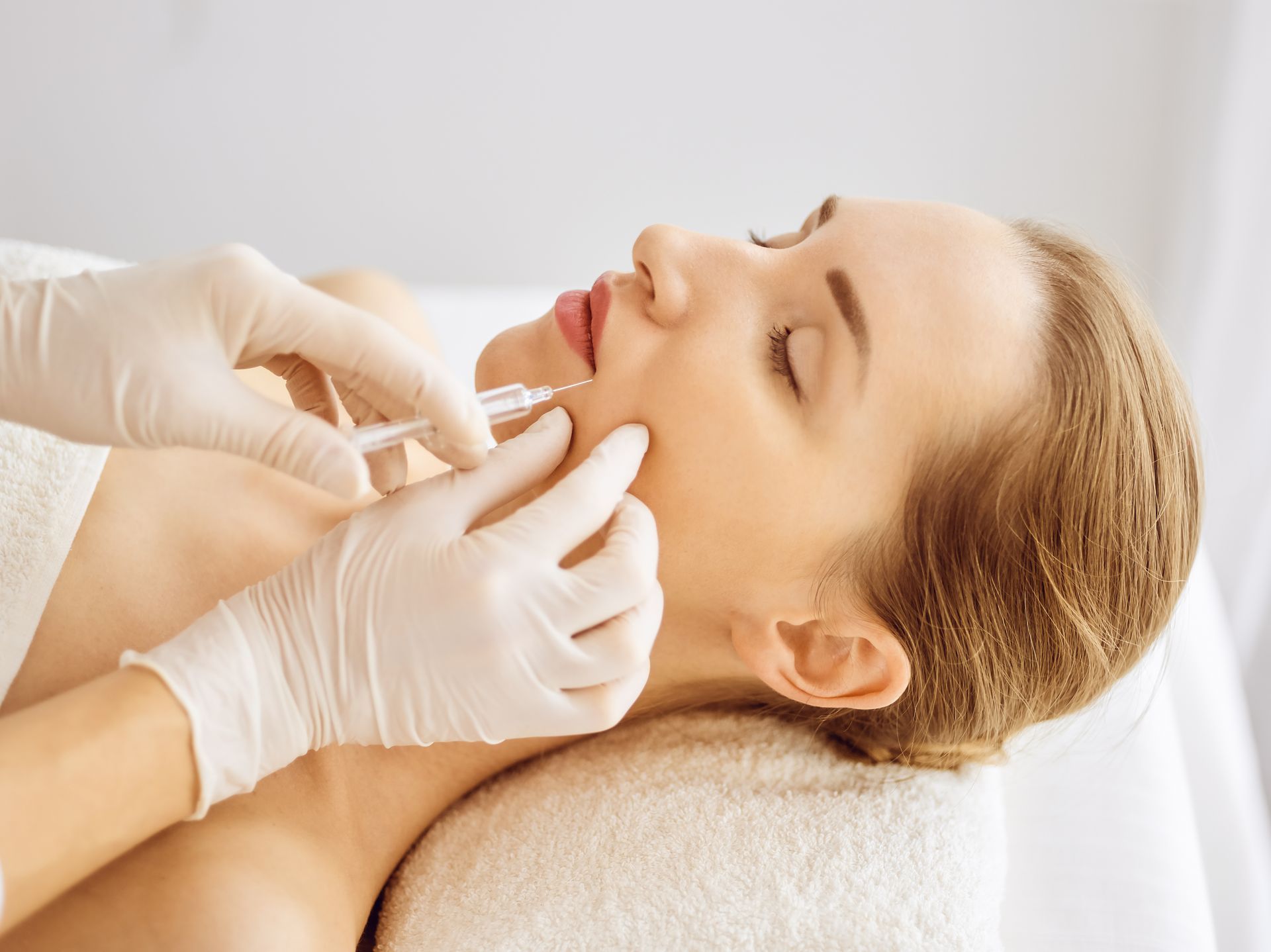 a woman is getting a botox injection in her forehead .