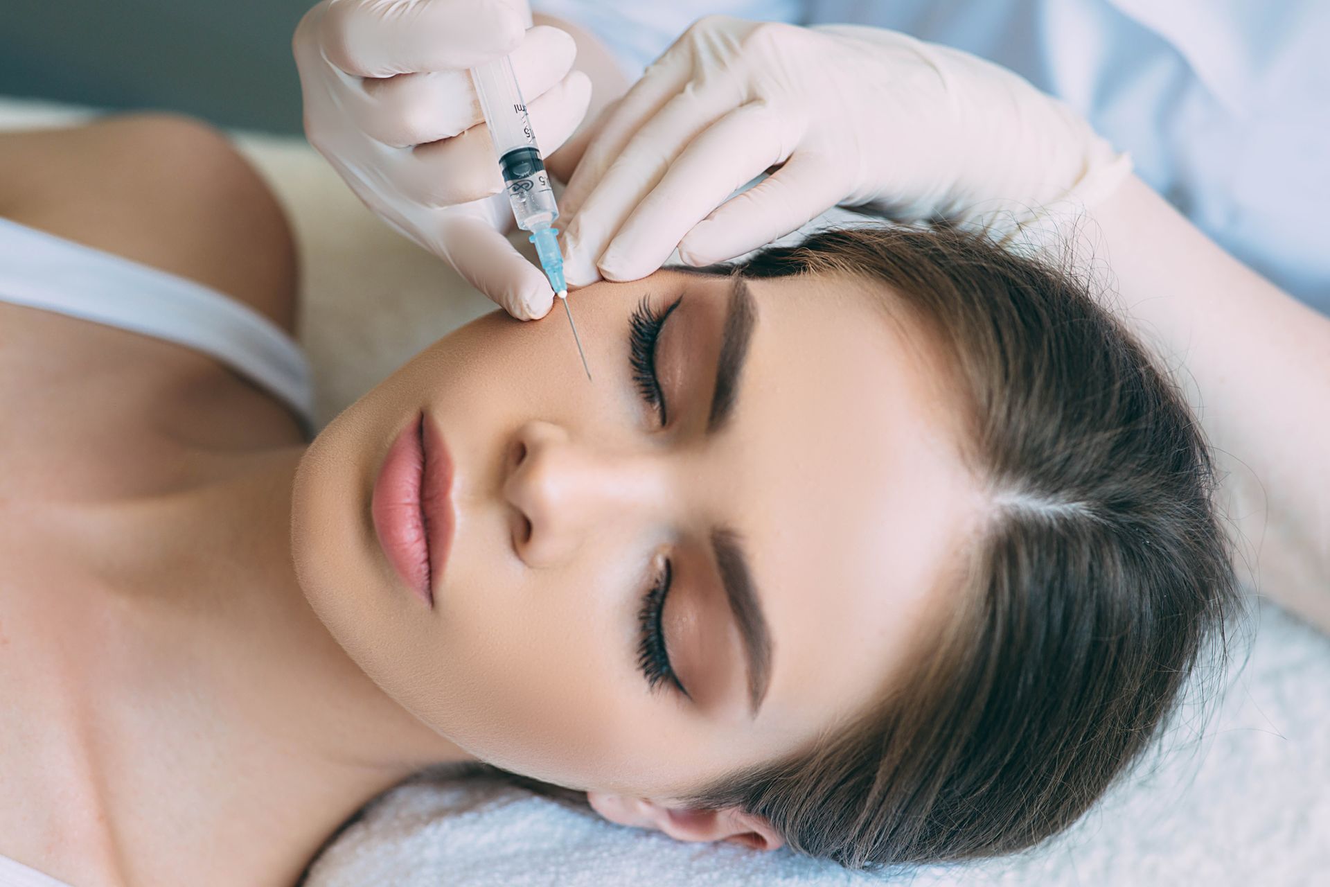 a woman is getting a botox injection in her face .
