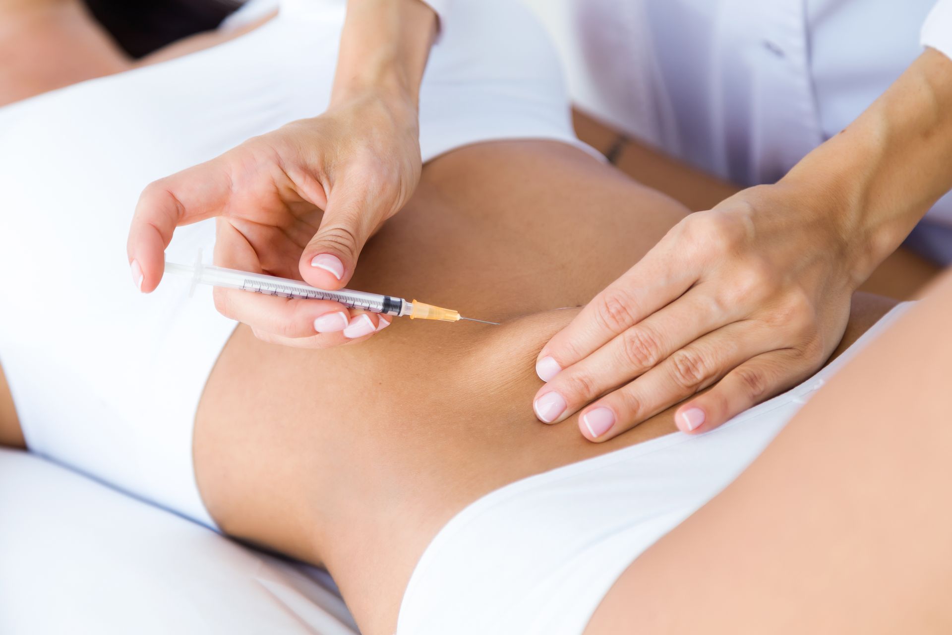 a woman is getting an injection in her stomach .