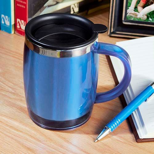 Blue mug with black lid and handle beside a pen and notebook on a desk