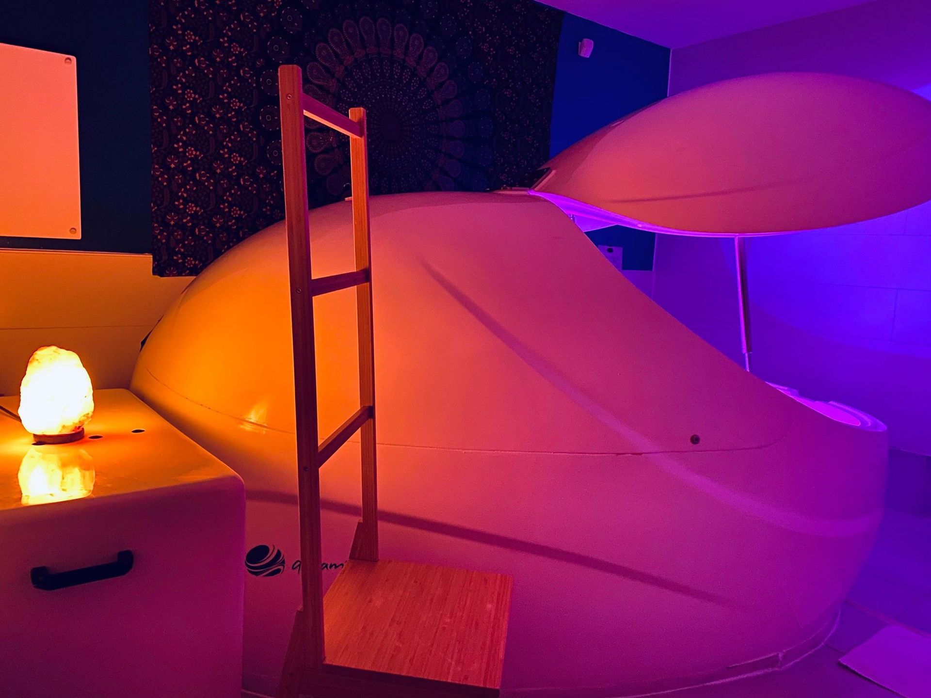 A room with a ladder and a lamp in it.