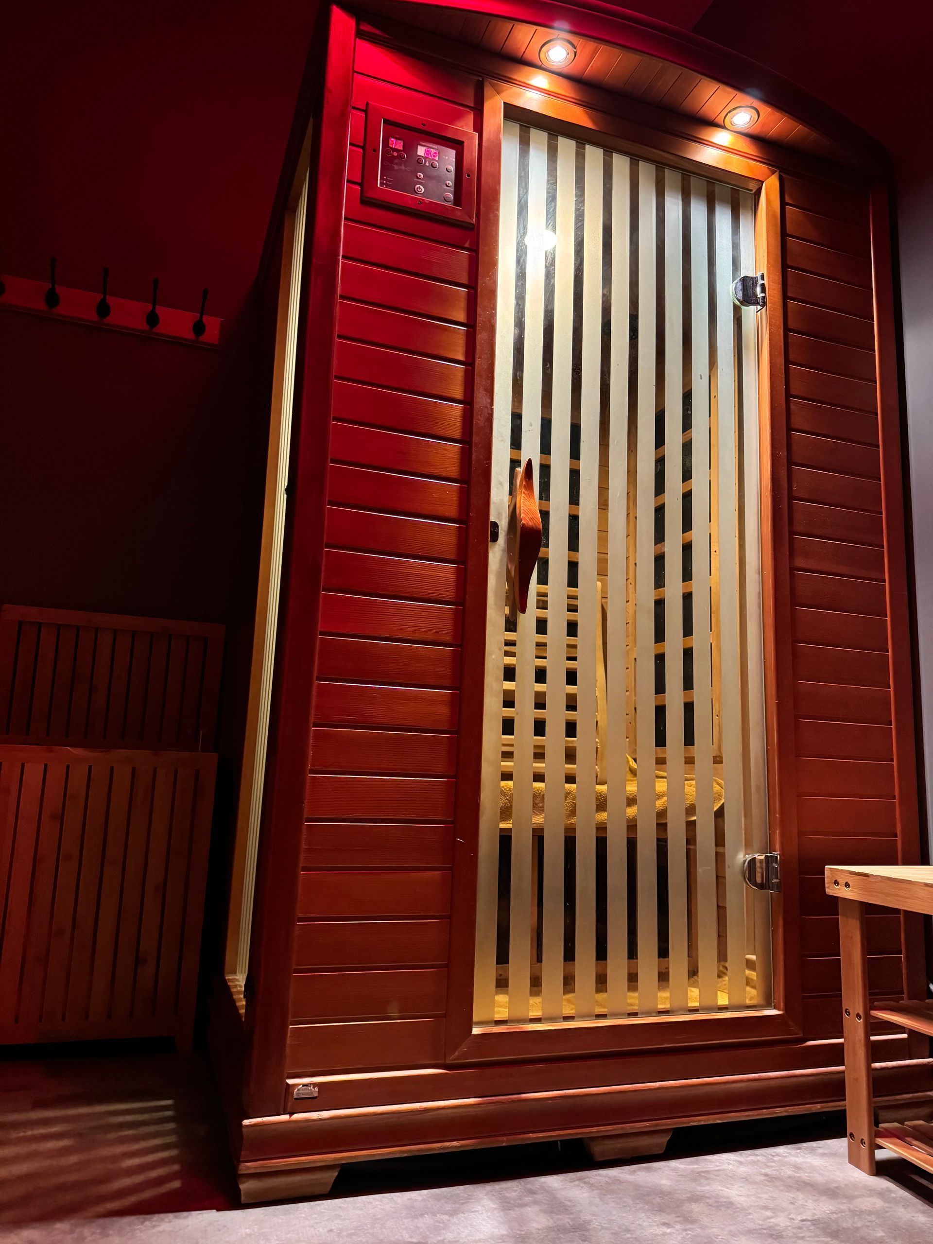 A wooden sauna with a glass door in a room.