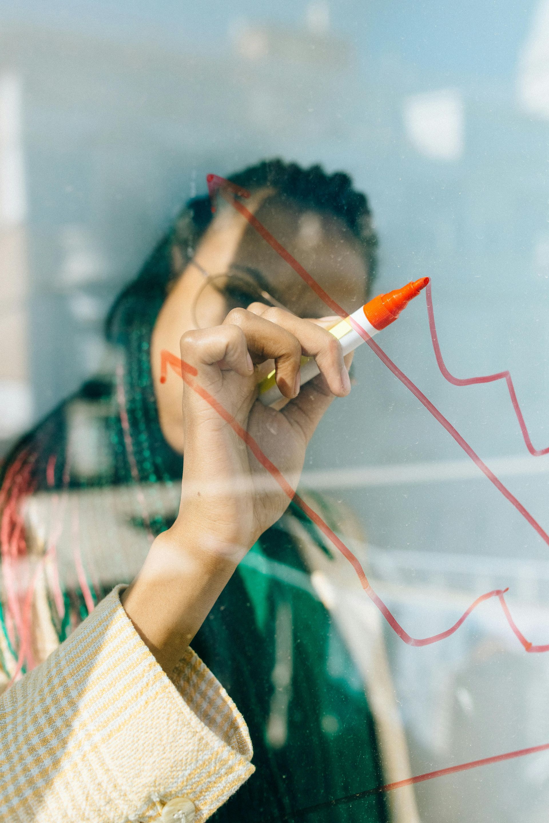 Person, die mit einem roten Marker ein Trenddiagramm aufzeichnet.