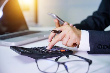 Man In Suit Using Calculator — Okmulgee, OK — Greg Marriott CPA PLLC Man In Suit Using Calculator — Okmulgee, OK — Greg Marriott CPA PLLC