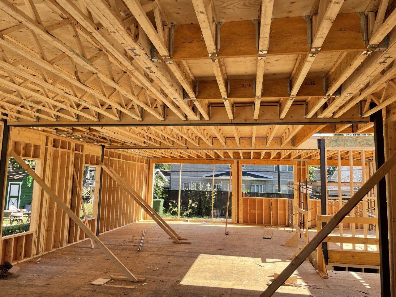 Une maison est en train d'être construite avec beaucoup de poutres en bois.