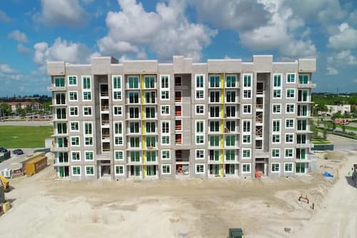 A residential building under construction getting windows installed.