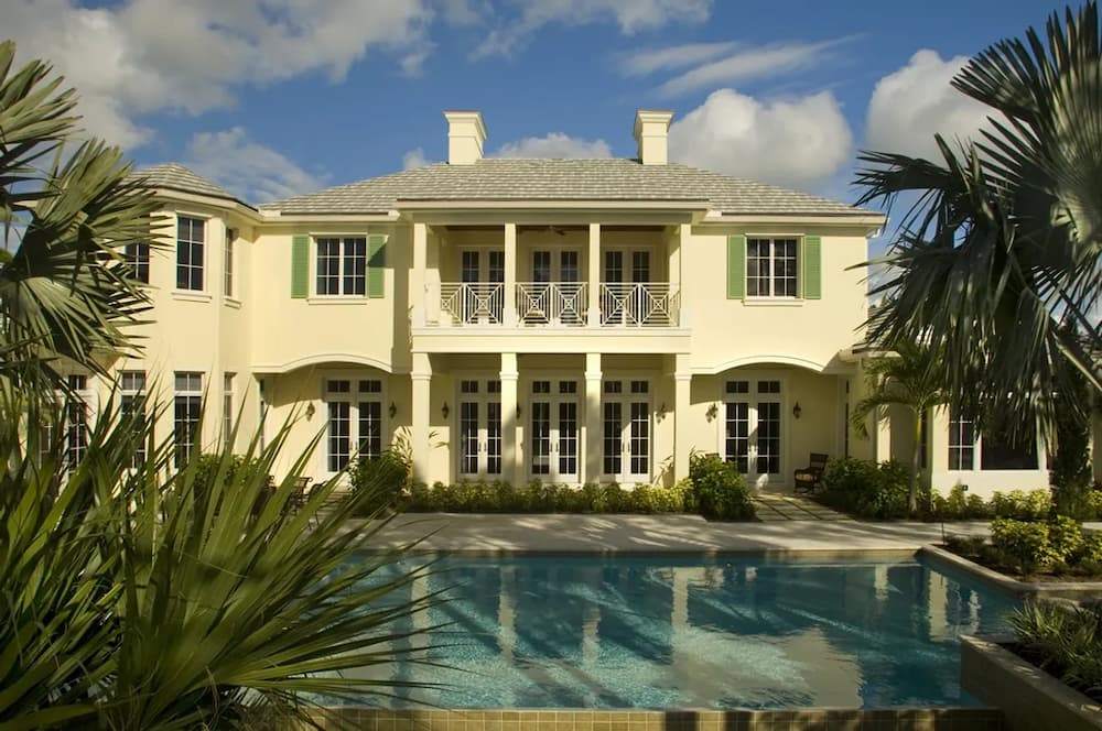 Luxury home with many impact doors leading to a pool.