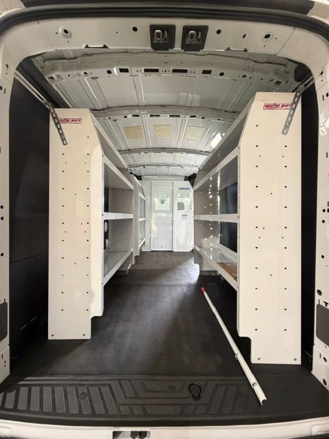 Interior of a white utility van with built-in shelves and an open cargo area