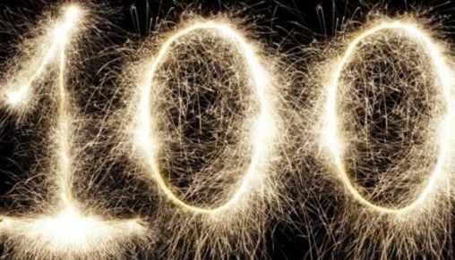 Three glowing sparkler-style “100” numerals on a dark background