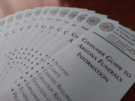 Stack of Arizona Funeral Information consumer guide booklets with a seal on the cover.