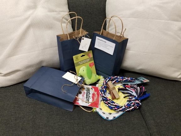 Gift bags, wrapped gifts, and colorful socks arranged on a couch.