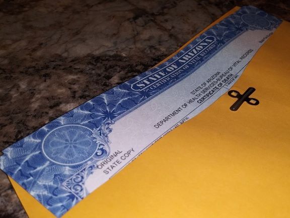 Blue patterned envelope on a countertop, next to a yellow package with a black scissors icon.