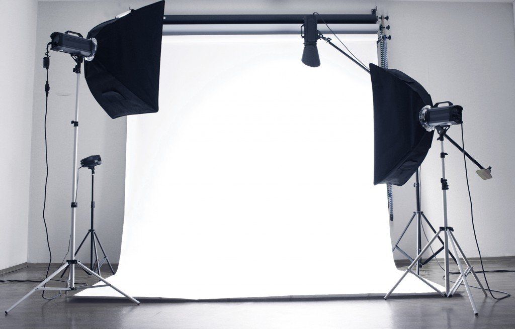 A photo studio with a white backdrop and black lights