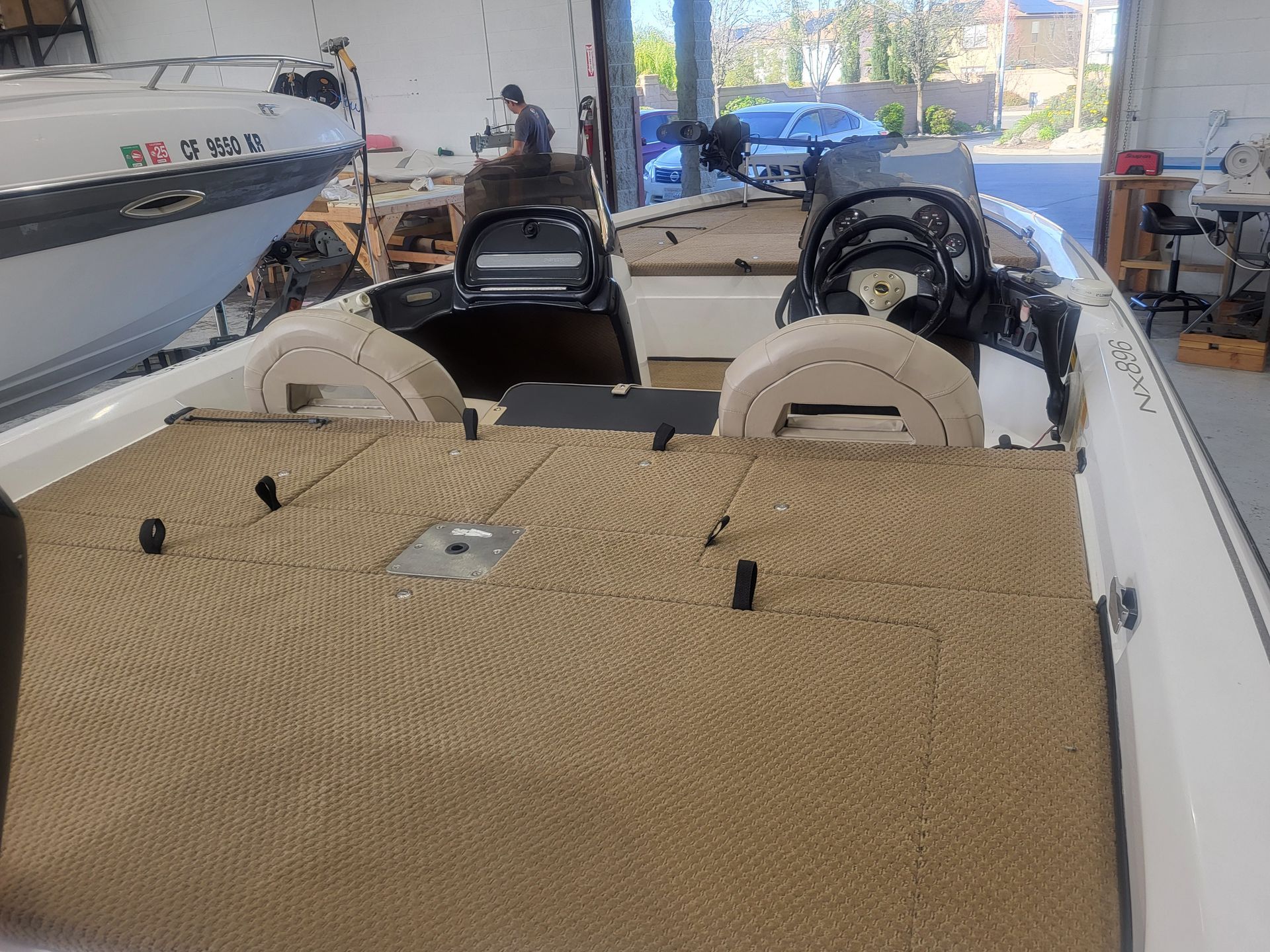 A boat is parked in a garage next to another boat.
