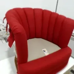 A red chair is sitting on top of a white table.